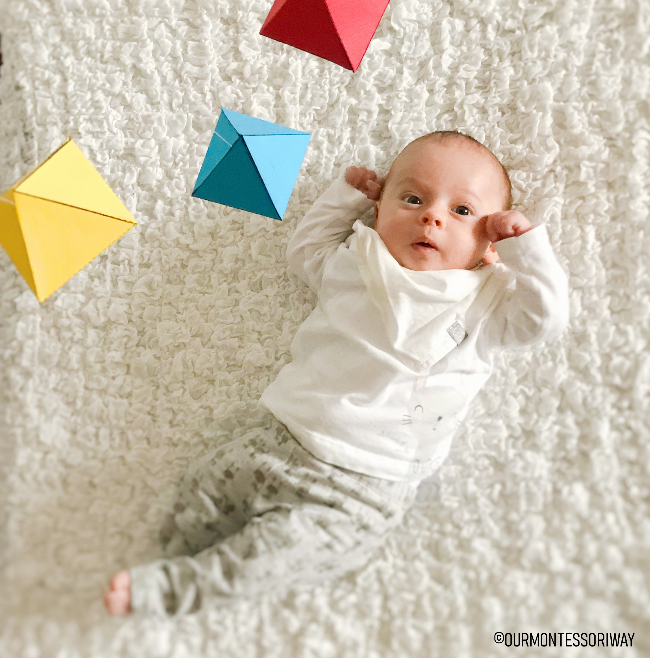 Baby in Bewegungsbereich mit Oktaeder Mobile