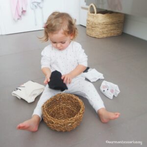 Montessori Badezimmer Körbchen mit Kleidung wird ausgeräumt