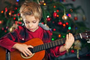 Junge spielt Gitarre in der Weihnachtszeit