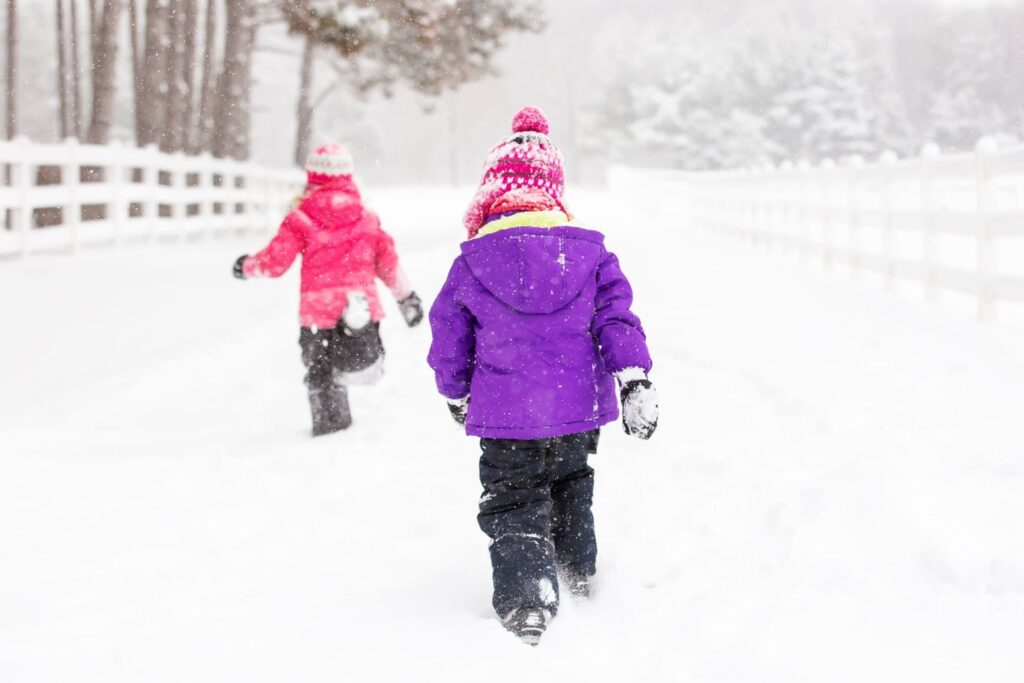 Spazieren im Schnee mit Mütze, Schal und Schneeanzug